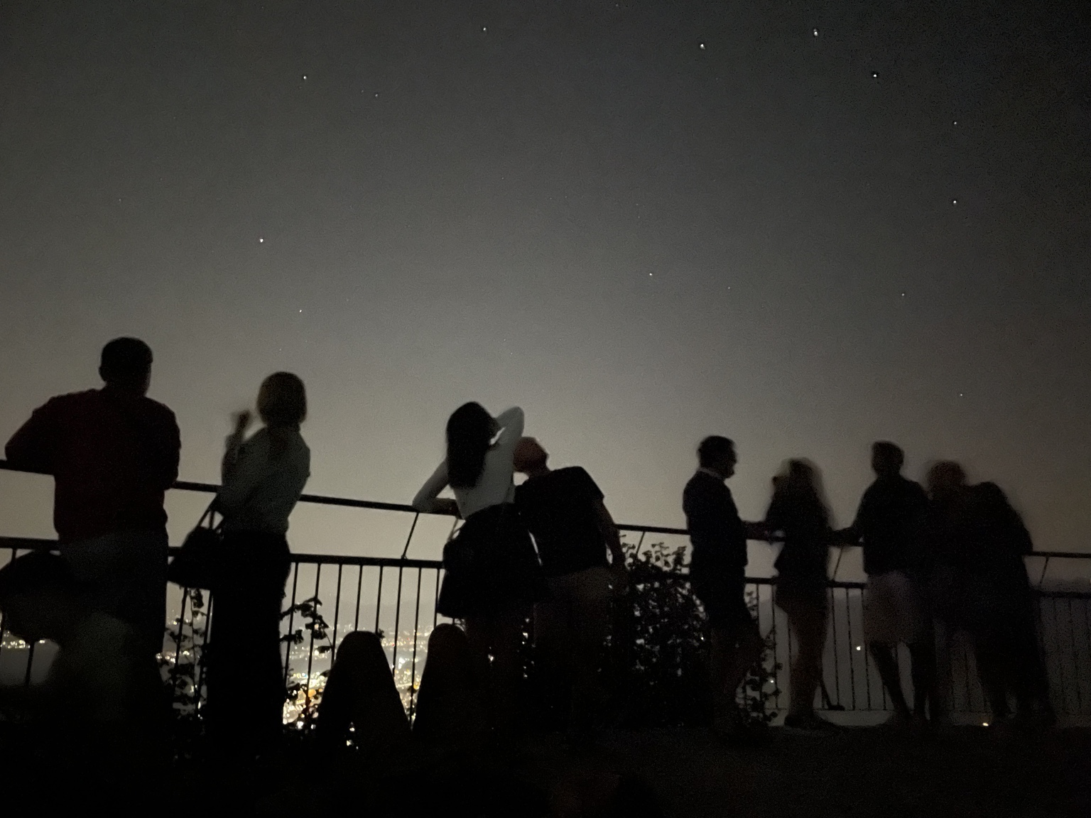 People silhouetted on a balcony at night