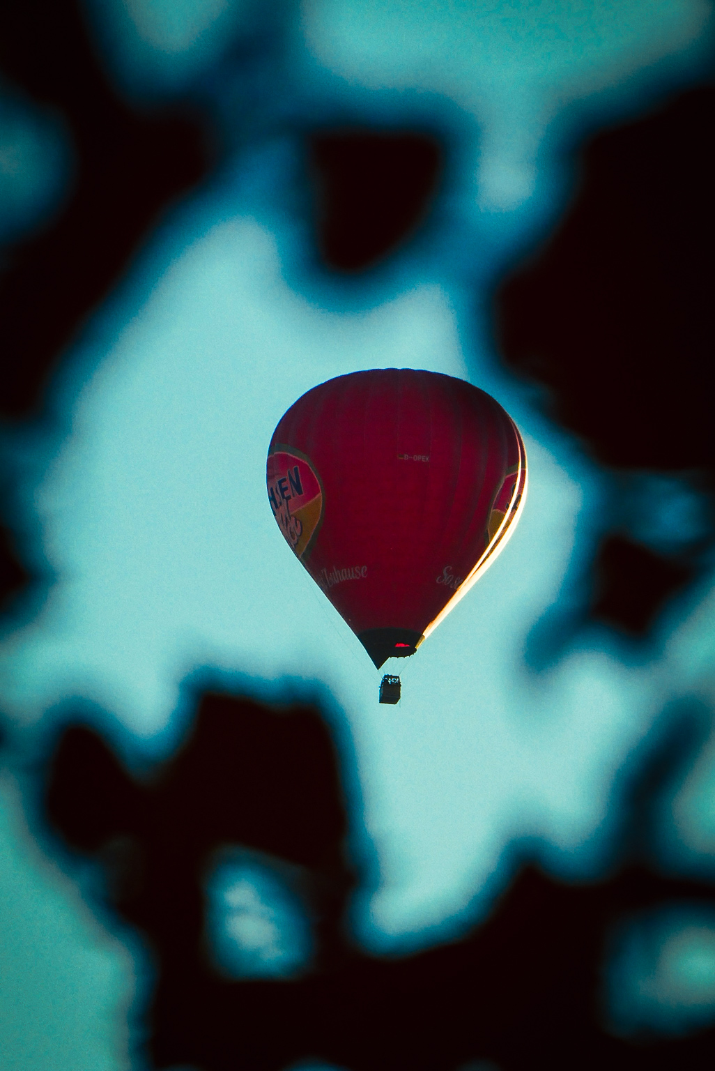 Red hot-air balloon seen through an abstract blue foreground